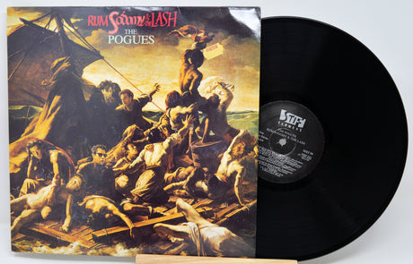 Vinyl record and cover of 'Rum O'Clock and the Lash' by The Pogues on a white background