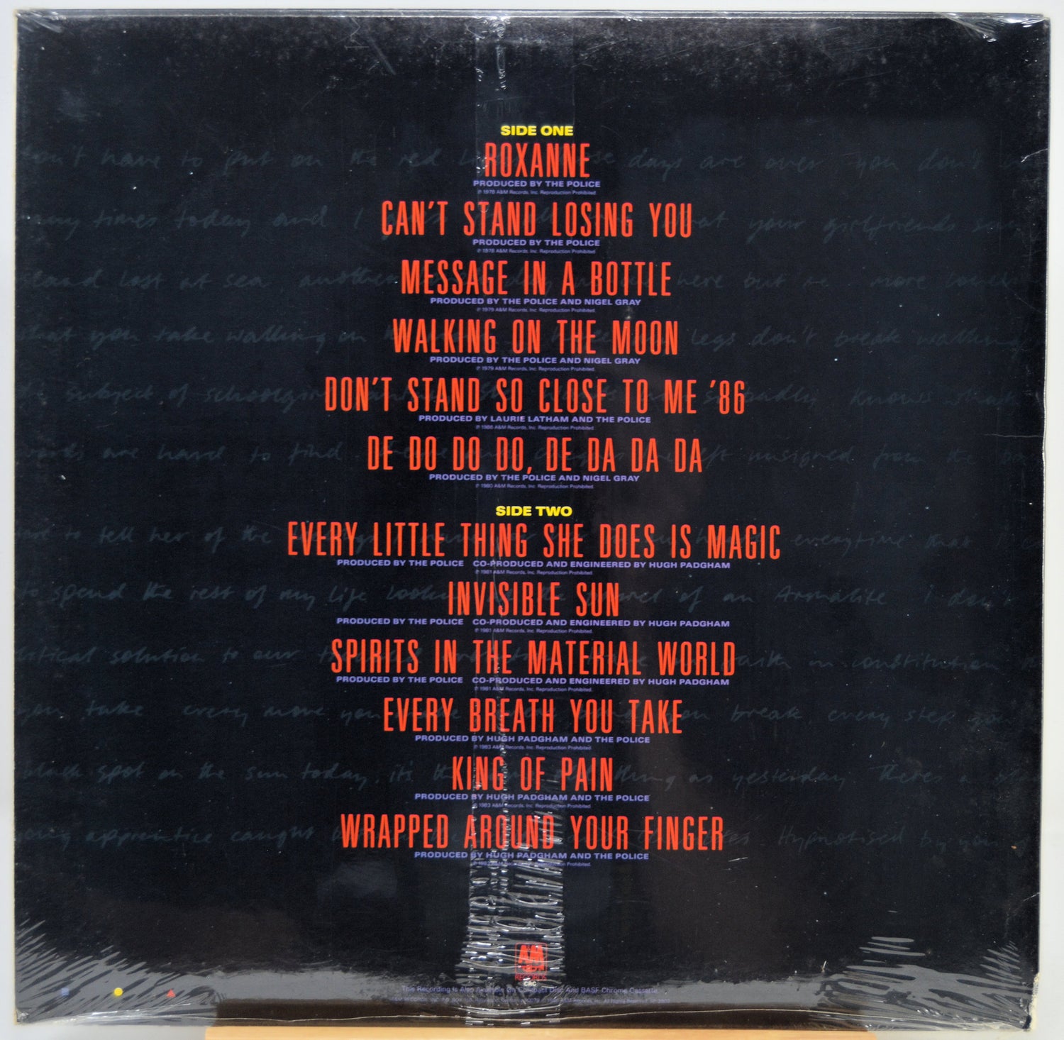 The back cover of a vinyl record featuring a black background with the tracklist printed in red and yellow text, wrapped in clear plastic.