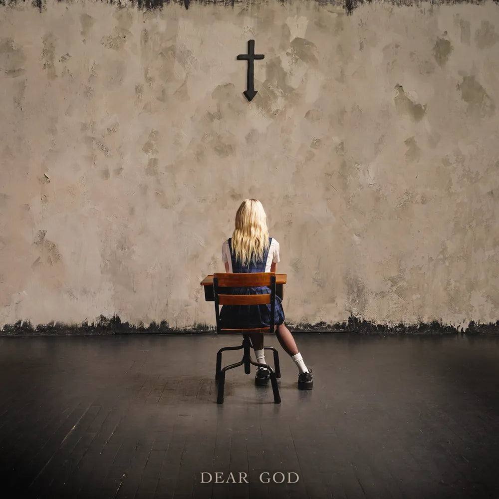 Person sitting on a chair in front of a textured wall with a cross, titled 'Dear God'.