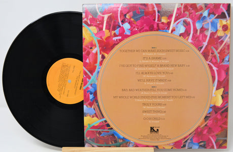 Vinyl record with colorful cover and black disc on a white background