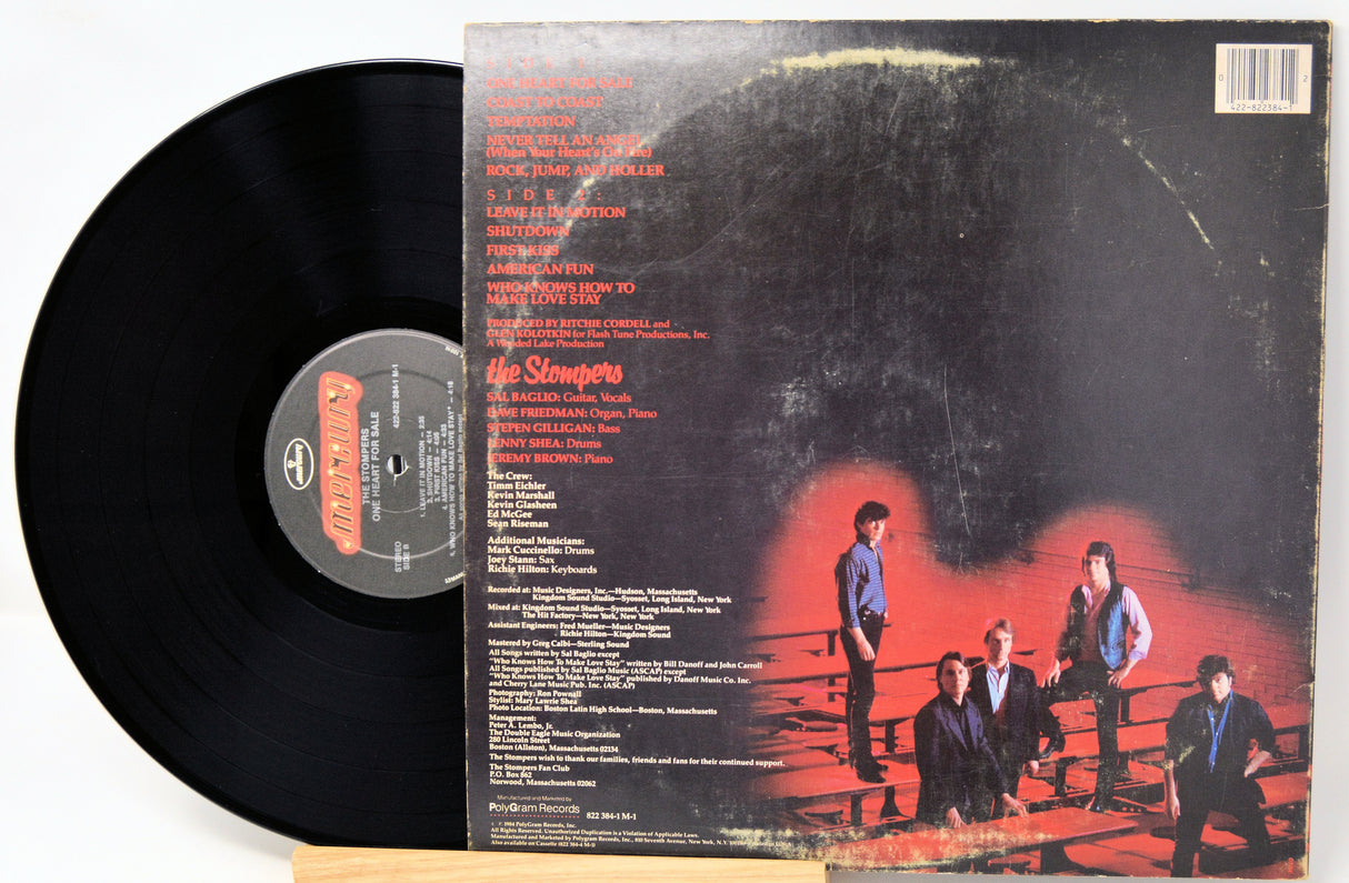 Vinyl record with cover featuring a band in a boxing ring on a black background