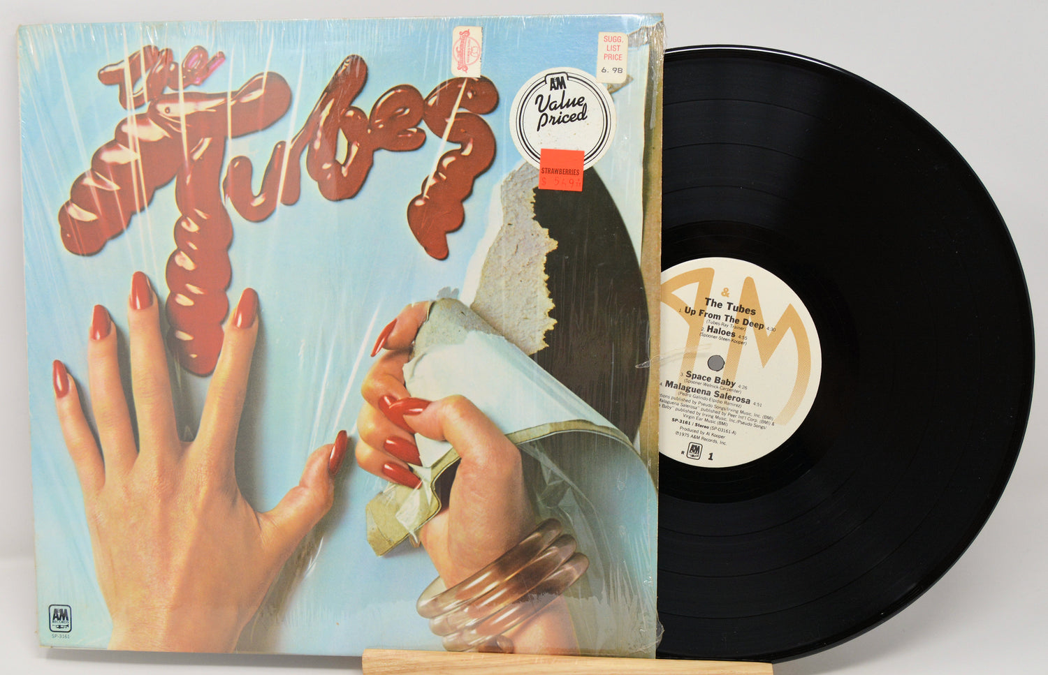 Vinyl record with cover featuring hands and text, on a white background