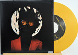 The Weekend Heartless variant #5 7 Inch Vinyl record with a black front cover featuring a person wearing sunglasses and a red jacket, and a yellow record inside.