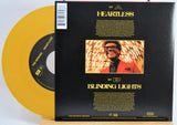 The Weekend Heartless variant #7 7 Inch Vinyl record with a black back cover featuring a person wearing sunglasses and a red jacket, and a yellow record inside.