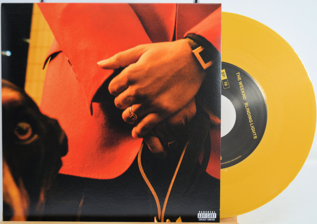 The Weekend Heartless variant #7 7 Inch Vinyl record with a black front cover featuring a person wearing sunglasses and a red jacket, and a yellow record inside.