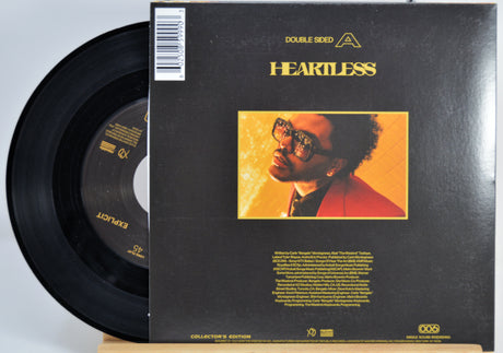 The Weeknd 7 Inch Vinyl record for 'Heartless' back cover featuring a person with glasses on a yellow background.