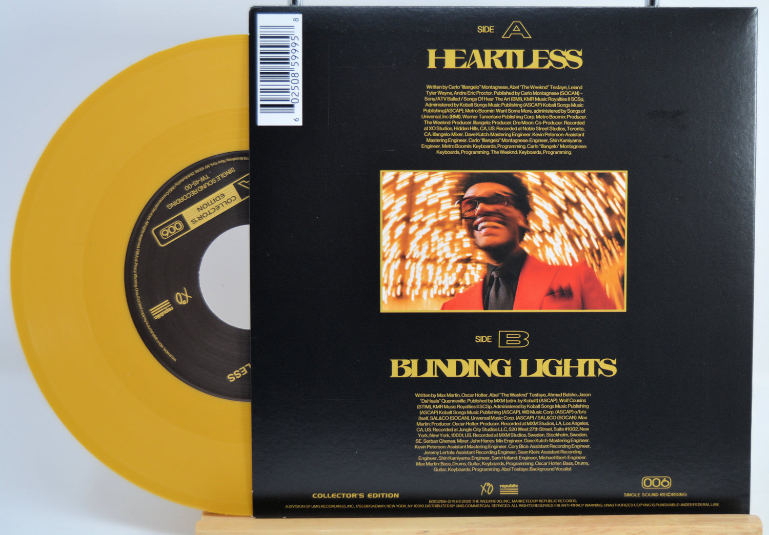 The Weekend Heartless variant #10 7 Inch Vinyl record with a black back cover featuring a person wearing sunglasses and a red jacket, and a yellow record inside.