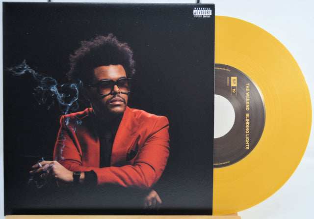 The Weekend Heartless variant #11 7 Inch Vinyl record with a black front cover featuring a person wearing sunglasses and a red jacket, and a yellow record inside.