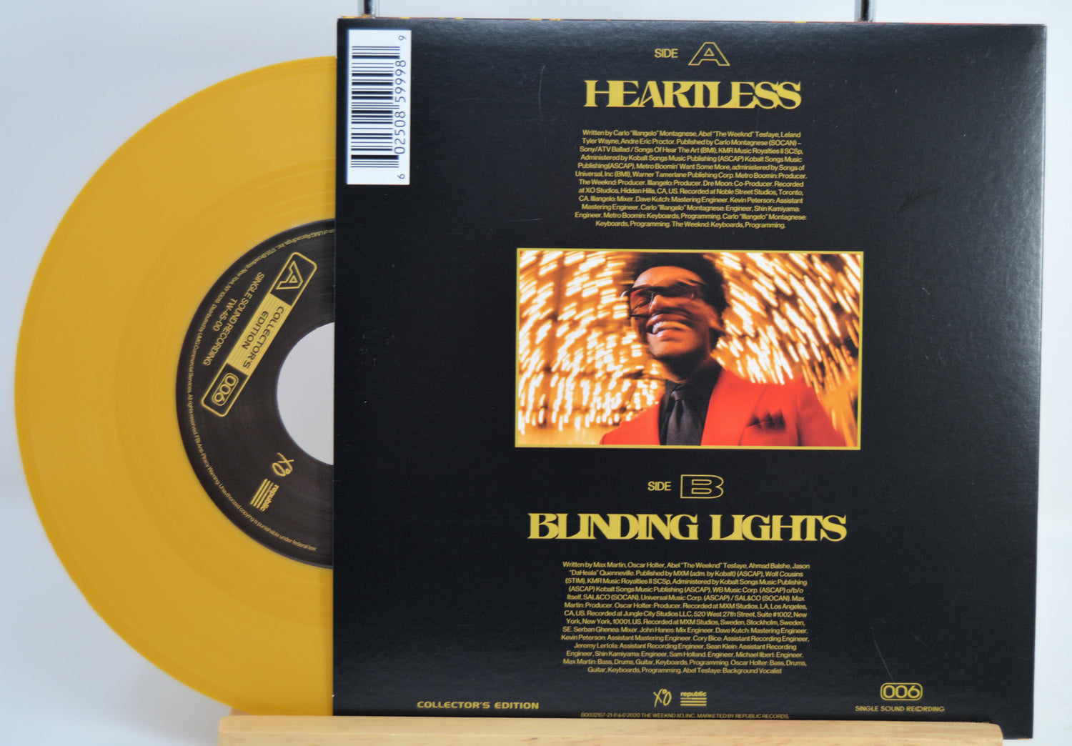 The Weekend Heartless variant #12 7 Inch Vinyl record with a black back cover featuring a person wearing sunglasses and a red jacket, and a yellow record inside.