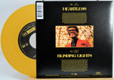 The Weekend Heartless variant #5 7 Inch Vinyl record with a black back cover featuring a person wearing sunglasses and a red jacket, and a yellow record inside.