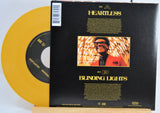 The Weekend Heartless variant #8 7 Inch Vinyl record with a black front cover featuring a person wearing sunglasses and a red jacket, and a yellow record inside.