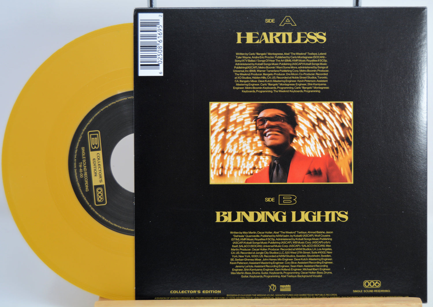 The Weekend Heartless variant #8 7 Inch Vinyl record with a black back cover featuring a person wearing sunglasses and a red jacket, and a yellow record inside.