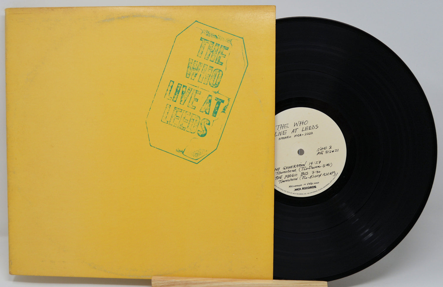 Vinyl record with yellow cover and black disc on a gray background