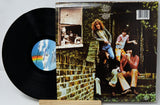 Vinyl record with a colorful label and cover featuring people sitting on steps.