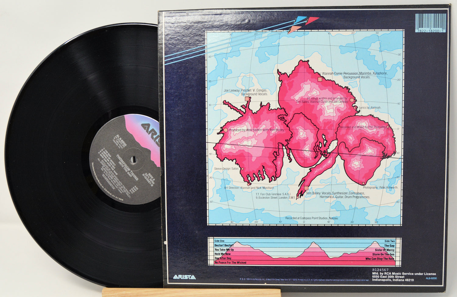 Vinyl record with a colorful cover featuring pink abstract designs on a white background