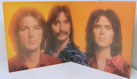 Album cover with three portraits of a man on a yellow background