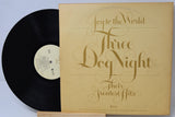 Vinyl record with 'Three Dog Night' album cover on a light blue background