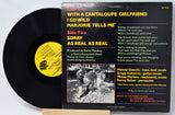 Vinyl record with cover featuring text and a black and white photo on a white background