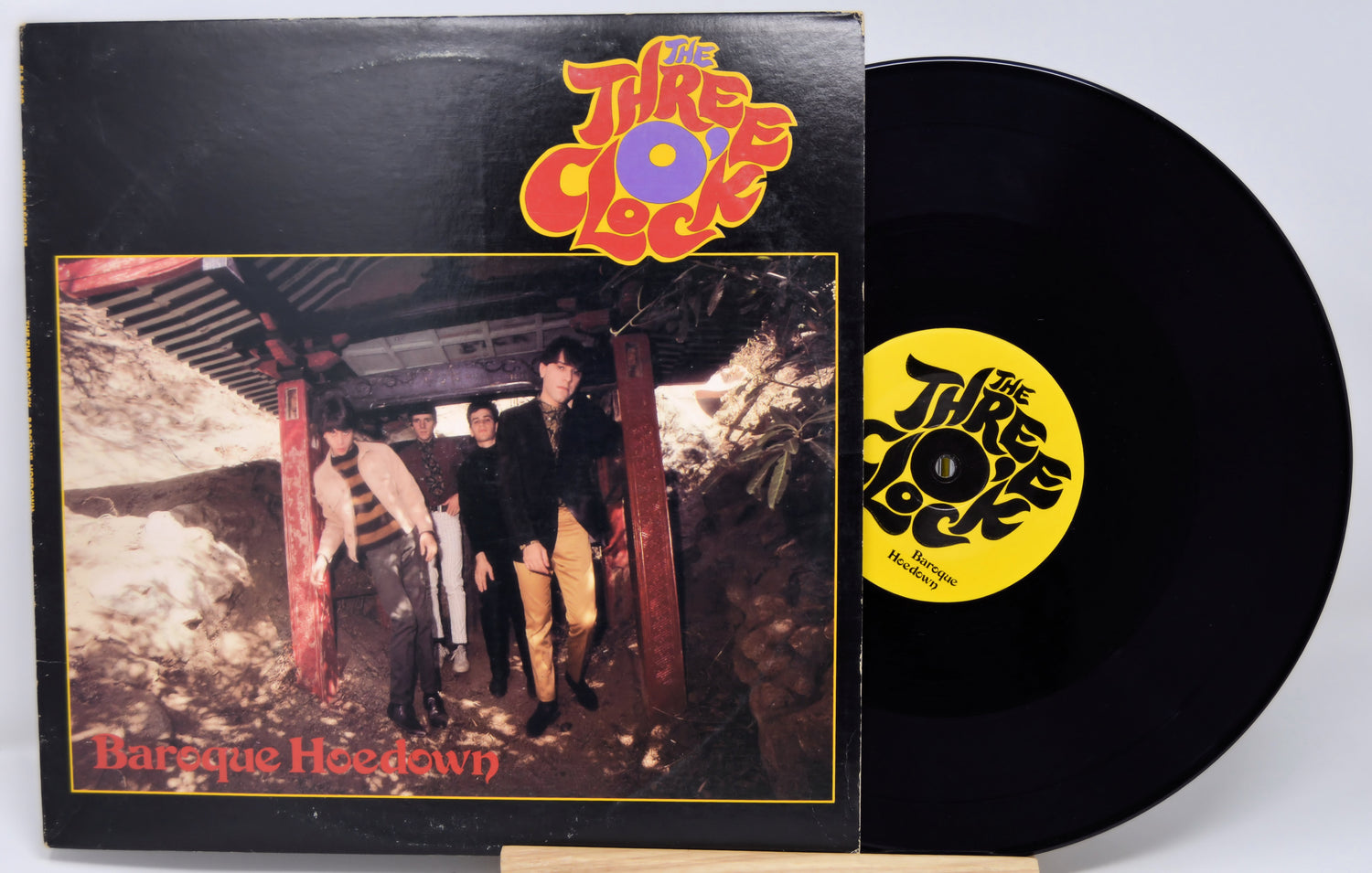 Vinyl record and cover with 'The Three Clocks' band on a white background