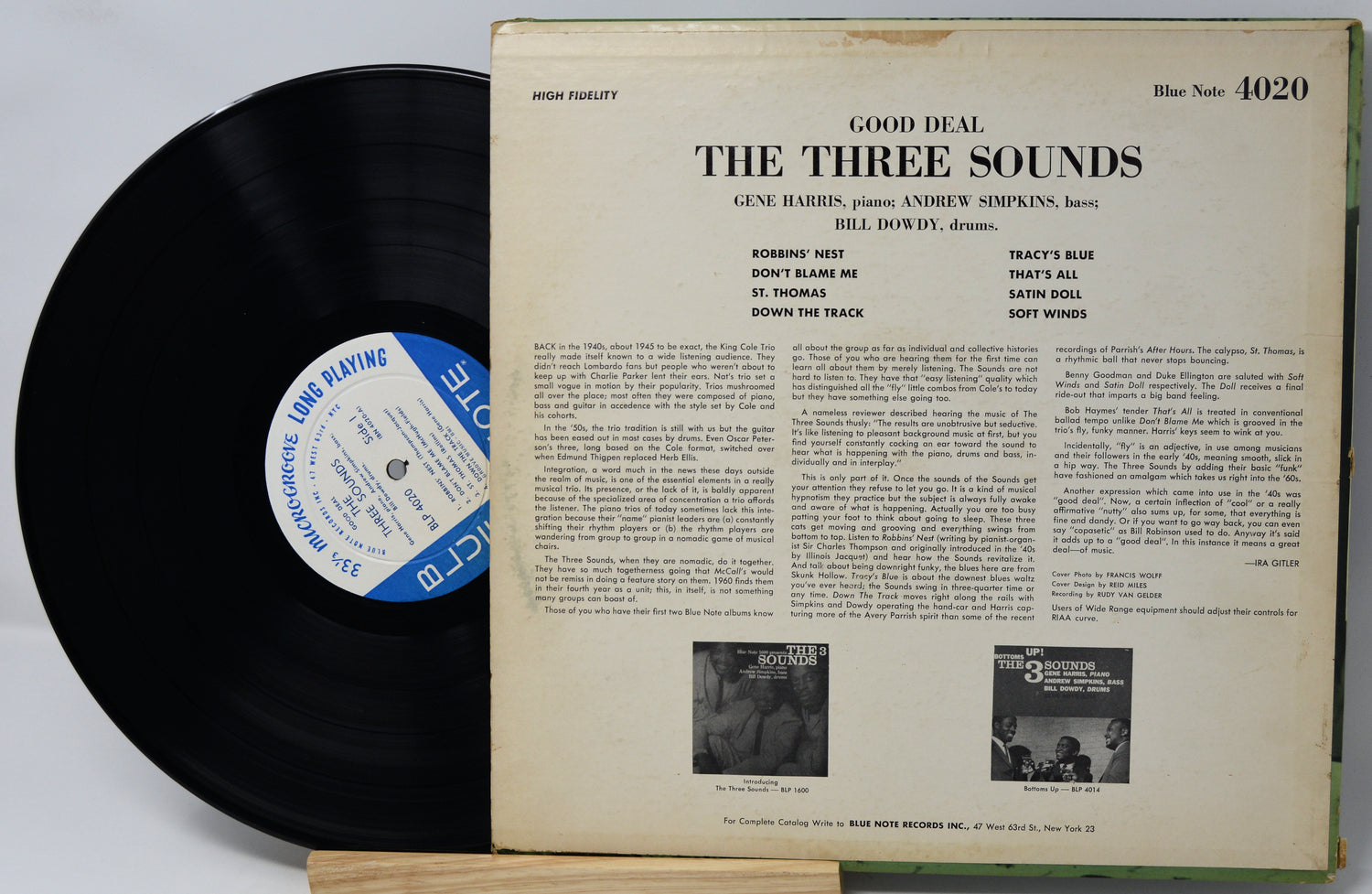 Vinyl record with cover displaying text and small black and white images on a light gray background
