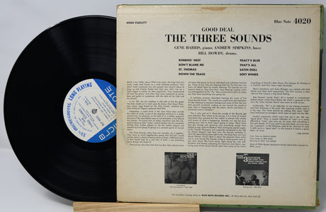 Vinyl record with cover displaying text and small black and white images on a light gray background