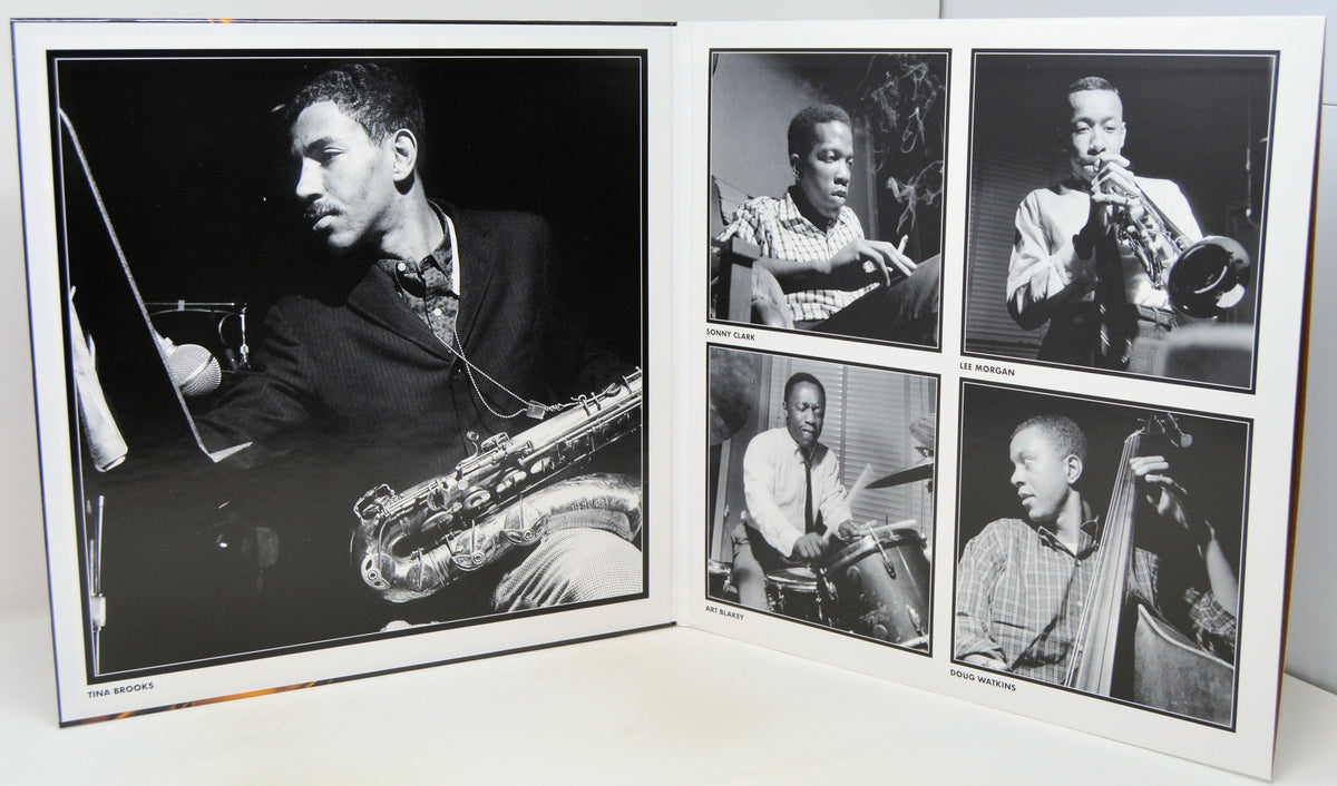 A black and white photographic print album or photo print set displayed open on a white surface, featuring multiple portraits of jazz musicians playing instruments such as saxophone, trumpet, drums, and double bass.