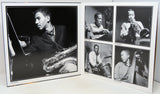 A black and white photographic print album or photo print set displayed open on a white surface, featuring multiple portraits of jazz musicians playing instruments such as saxophone, trumpet, drums, and double bass.