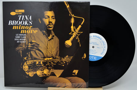 Vinyl record album for Tina Brooks' 'minor move' with the black LP partially pulled from the sleeve, photographed on a light gray background.