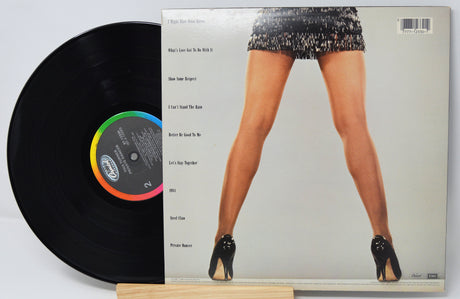 Vinyl record with a cover featuring a person in high heels and sequin shorts.