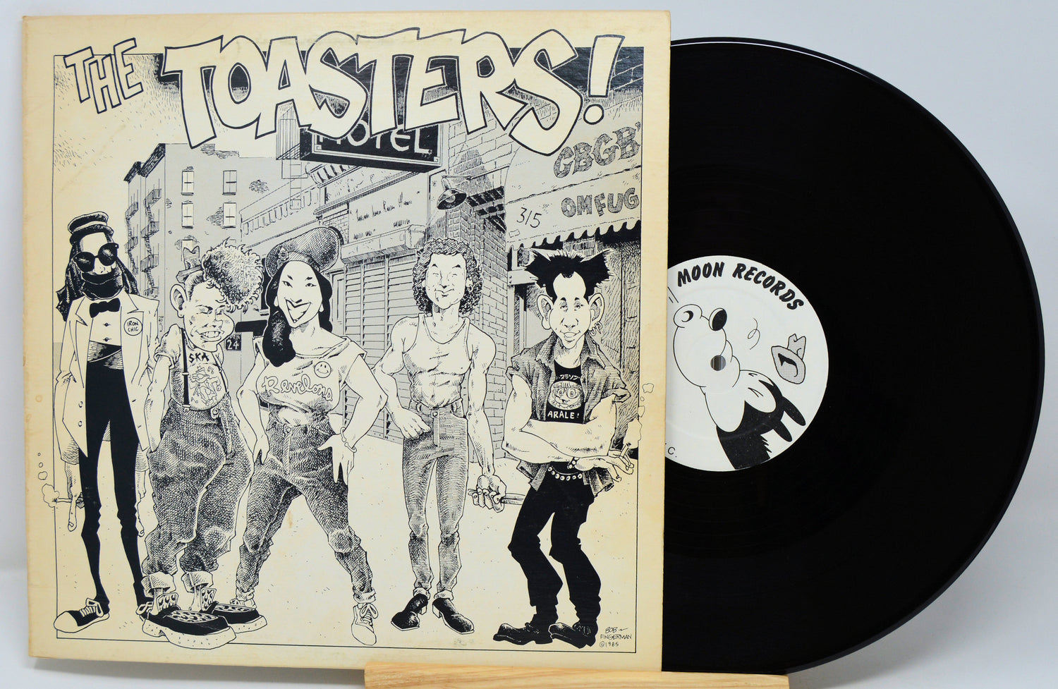 Vinyl record with cover featuring illustrations of people and text 'The Toasters' on a light background.