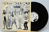 Vinyl record with cover featuring illustrations of people and text 'The Toasters' on a light background.