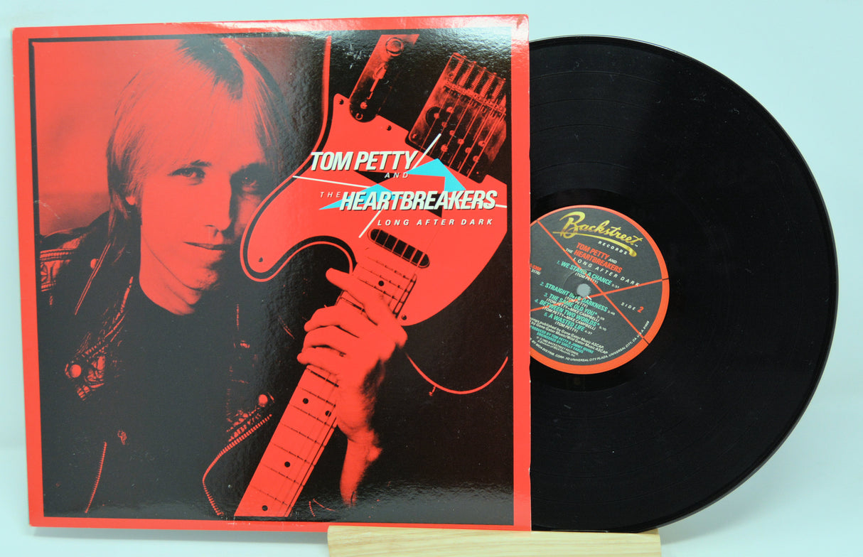 Vinyl record with cover featuring Tom Petty holding a guitar, on a red background.