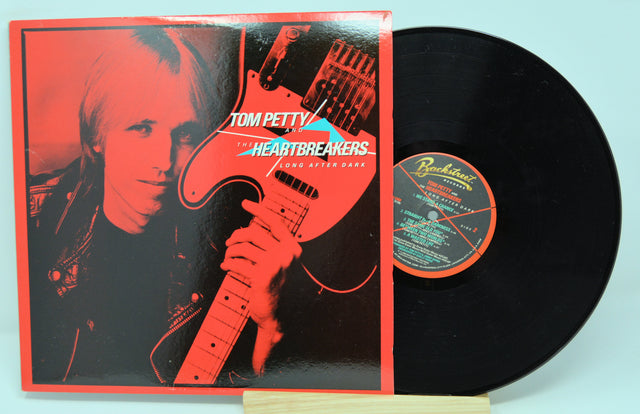 Vinyl record with cover featuring Tom Petty holding a guitar, on a red background.