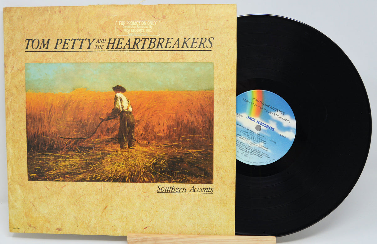 Vinyl record with a colorful album cover featuring a tropical scene and geometric shapes.