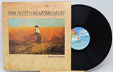 Tom Petty and the Heartbreakers 'Southern Accents' vinyl record LP with the album cover in front and the black record partially pulled out, showing the blue label.
