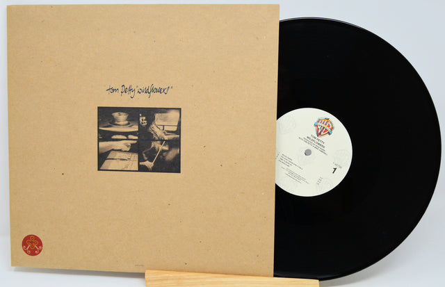 Tom Petty's 'Self Owned' vinyl record album, showing the tan paper sleeve with handwritten title and black-and-white photo, next to the black LP record on a white background.