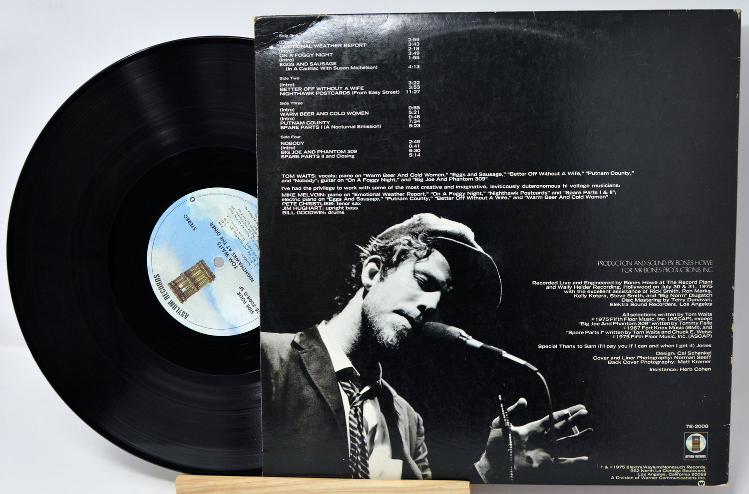 Vinyl record with cover featuring a black and white image of a person playing guitar.