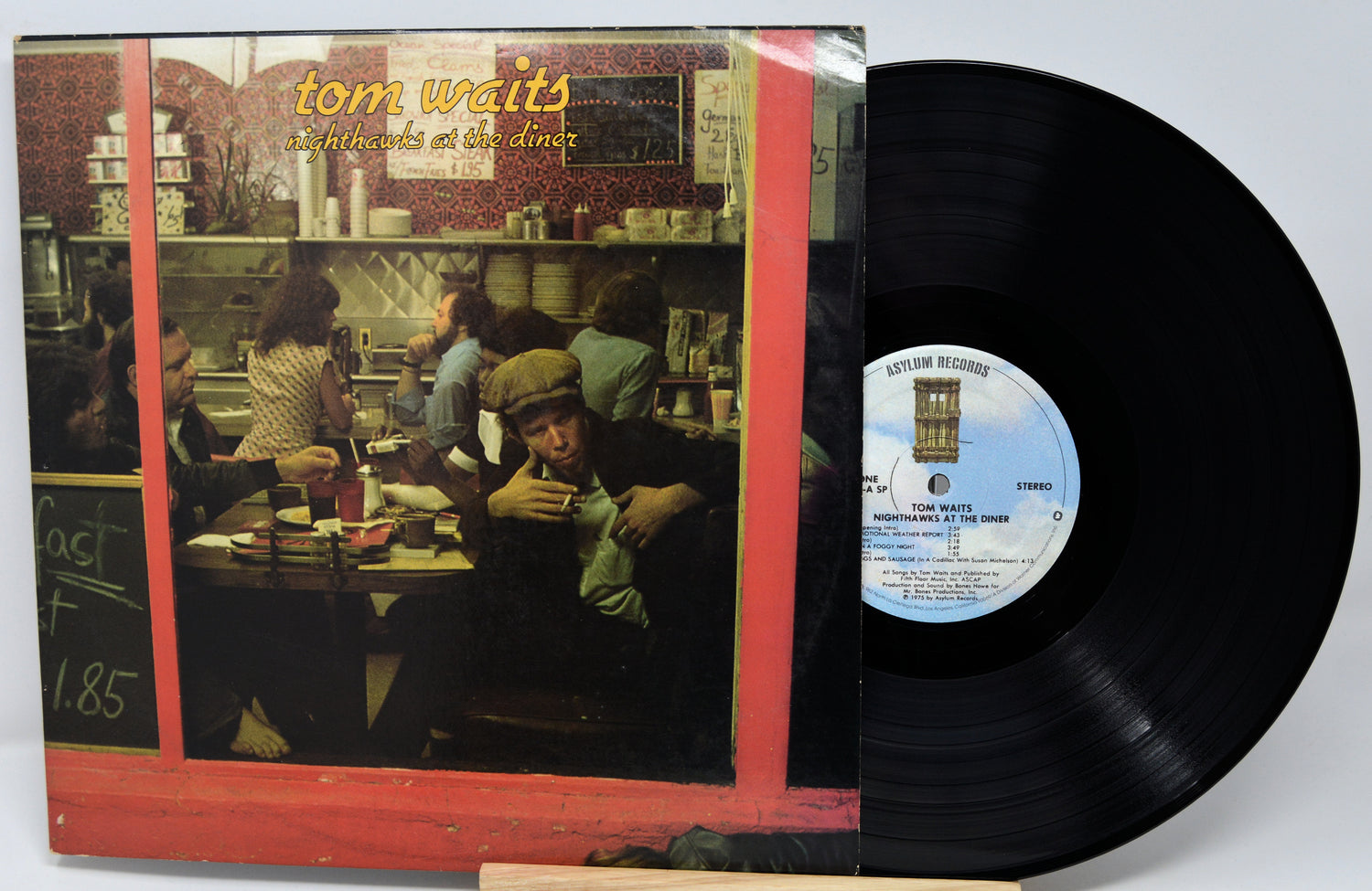 Vinyl record with cover featuring a diner scene and 'Tom Waits' text.