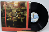 Vinyl record with cover featuring a diner scene and 'Tom Waits' text.