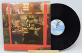 Vinyl record 'Tom Waits Nighthawks At the Diner' with cover featuring a scene from a movie, on a white background