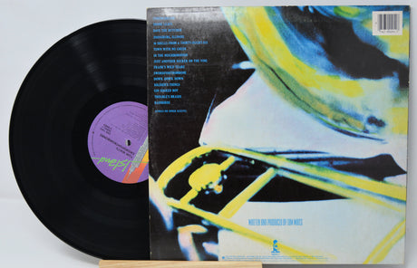 Vinyl record 'Tom Waits Swordfishtrombones' with colorful back cover featuring a face and abstract design.