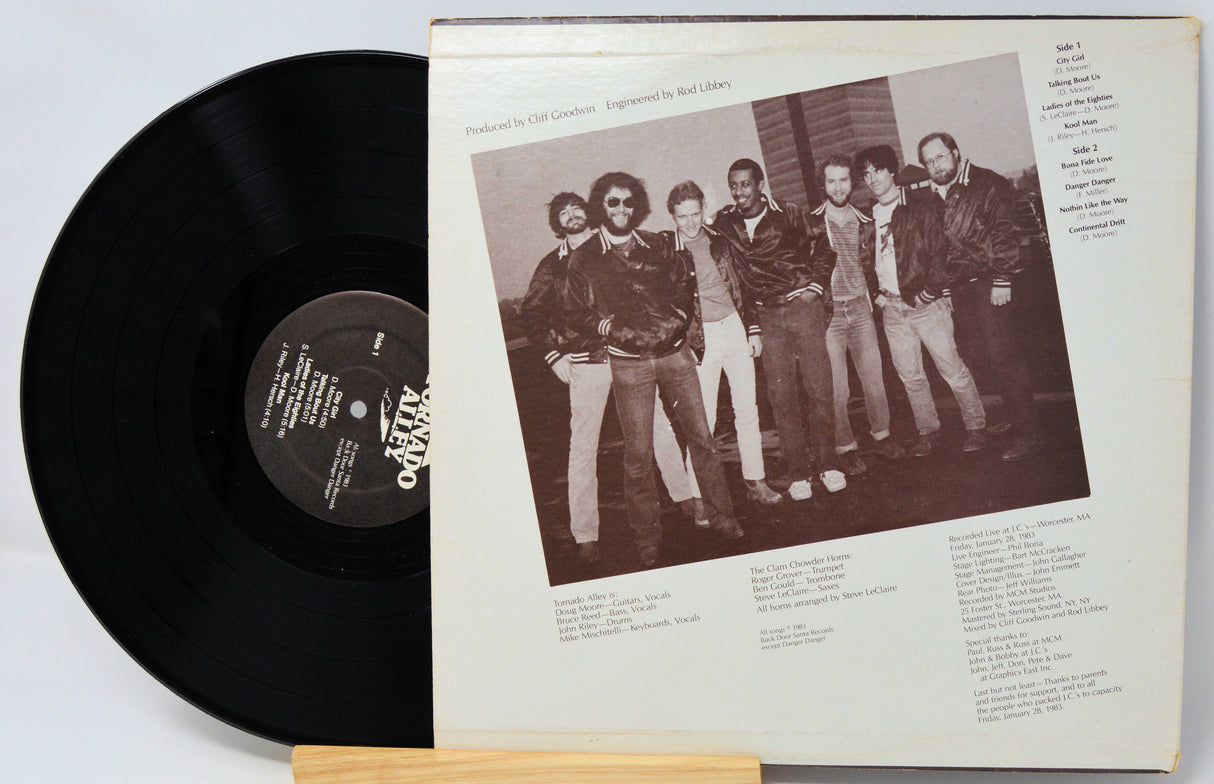 Vinyl record with cover featuring a group of people on a white background