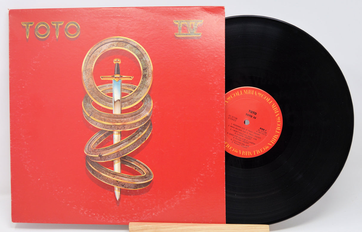 Vinyl record with red cover featuring a spiral design and 'Toto' branding.