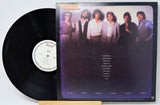 Vinyl record with cover featuring a group of people on a white background