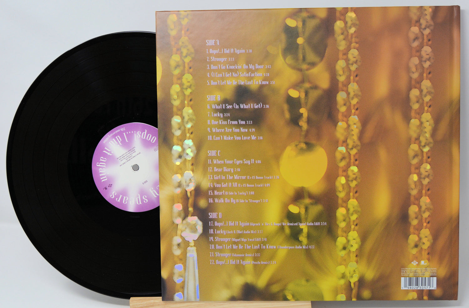 Back cover and black vinyl record of Oops!... I Did It Again 25th Anniversary edition showing tracklist