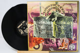 Shelby Michael's 'Trampoline to Tread' vinyl record LP with its illustrated cover jacket displayed next to the black record on a small wooden stand.