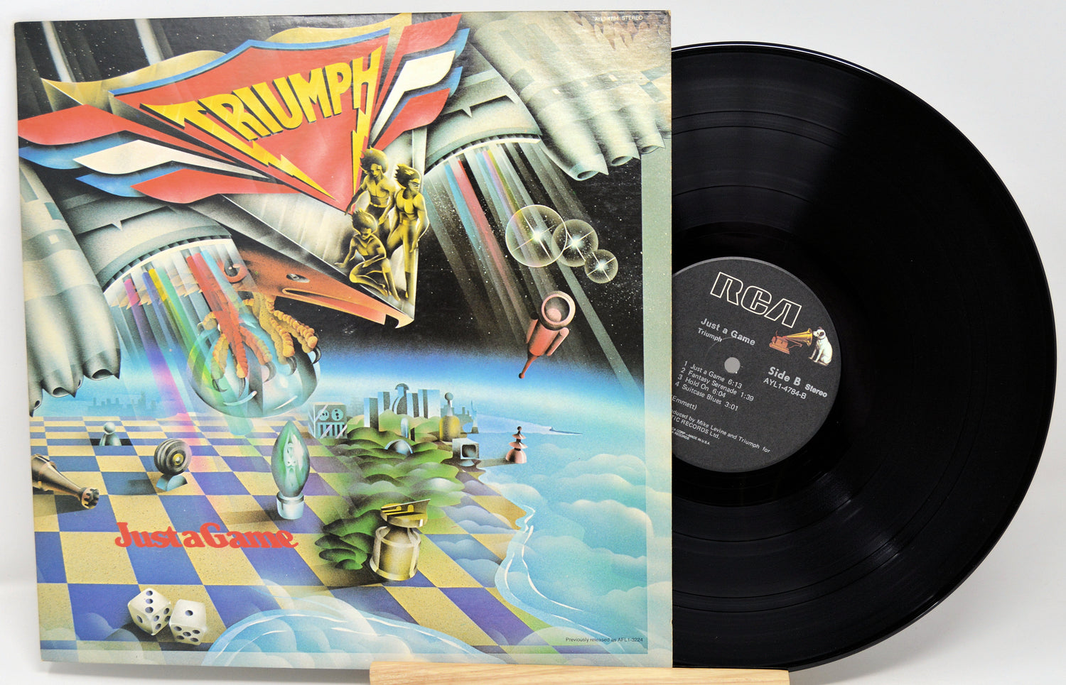 Vinyl record with colorful album cover featuring 'Triumph' and 'Just a Game'.