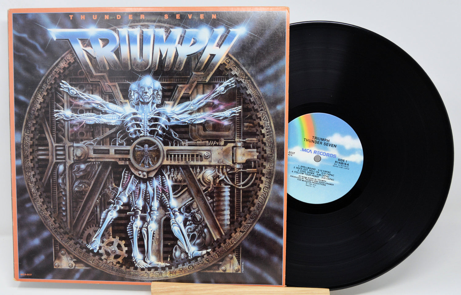 Vinyl record with cover featuring a mechanical design and 'Triumph' branding.