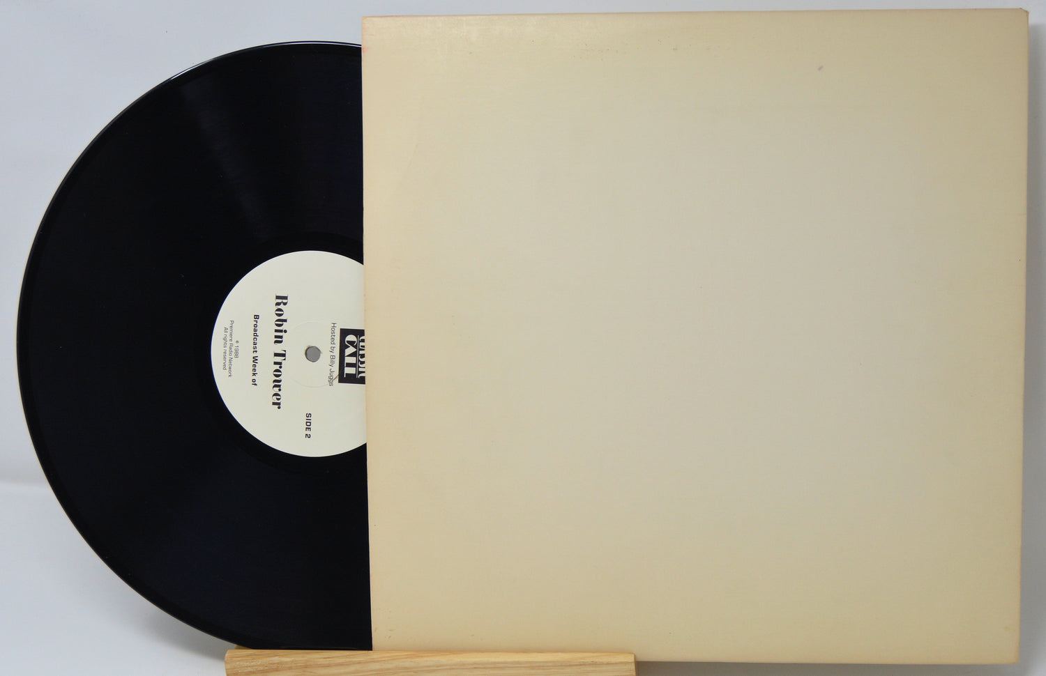 Vinyl record with a beige sleeve on a light gray background