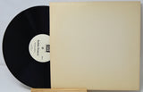 Vinyl record with a beige sleeve on a light gray background
